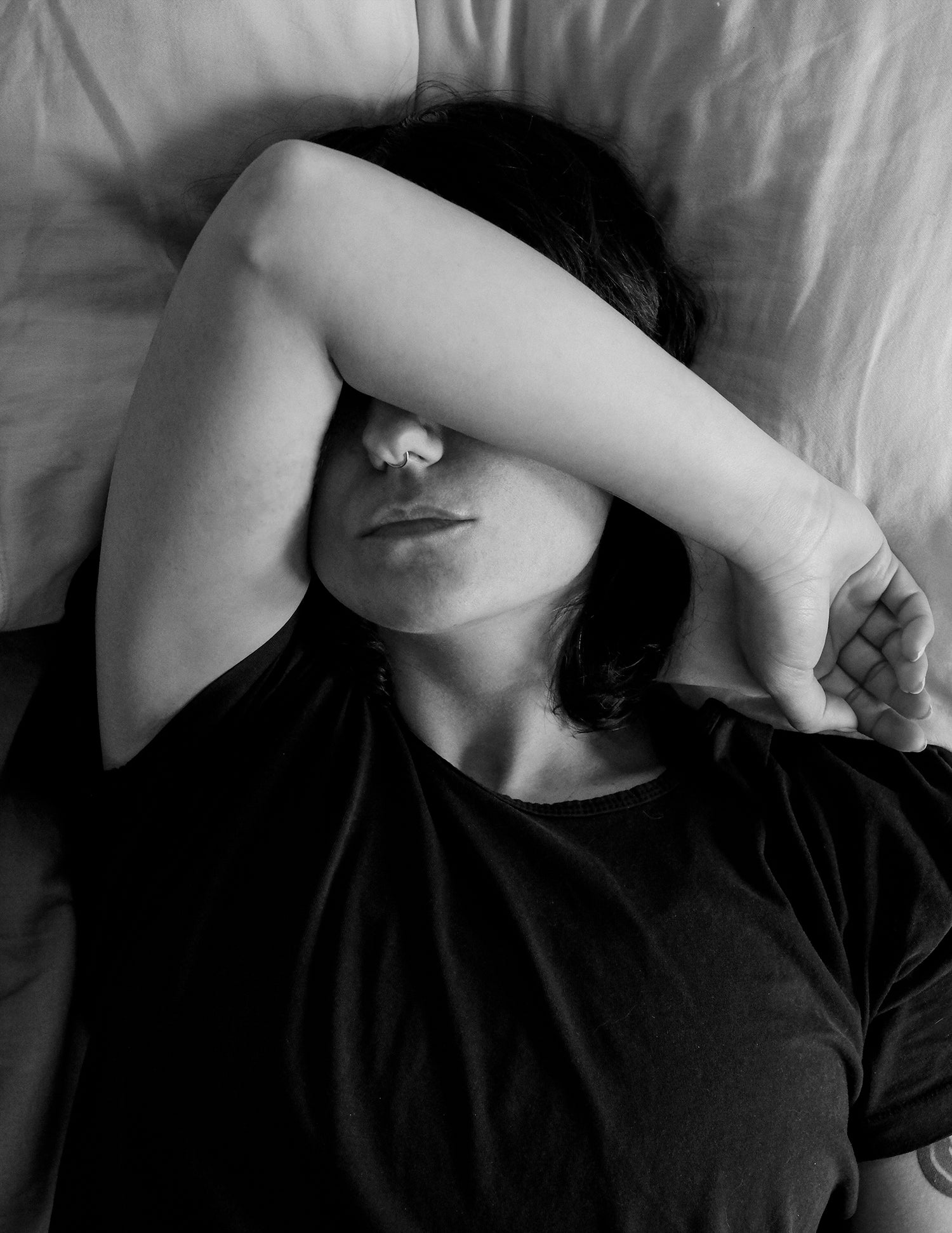 PERSON-LYING-WITH-THEIR-ARM-UP-IN-BED