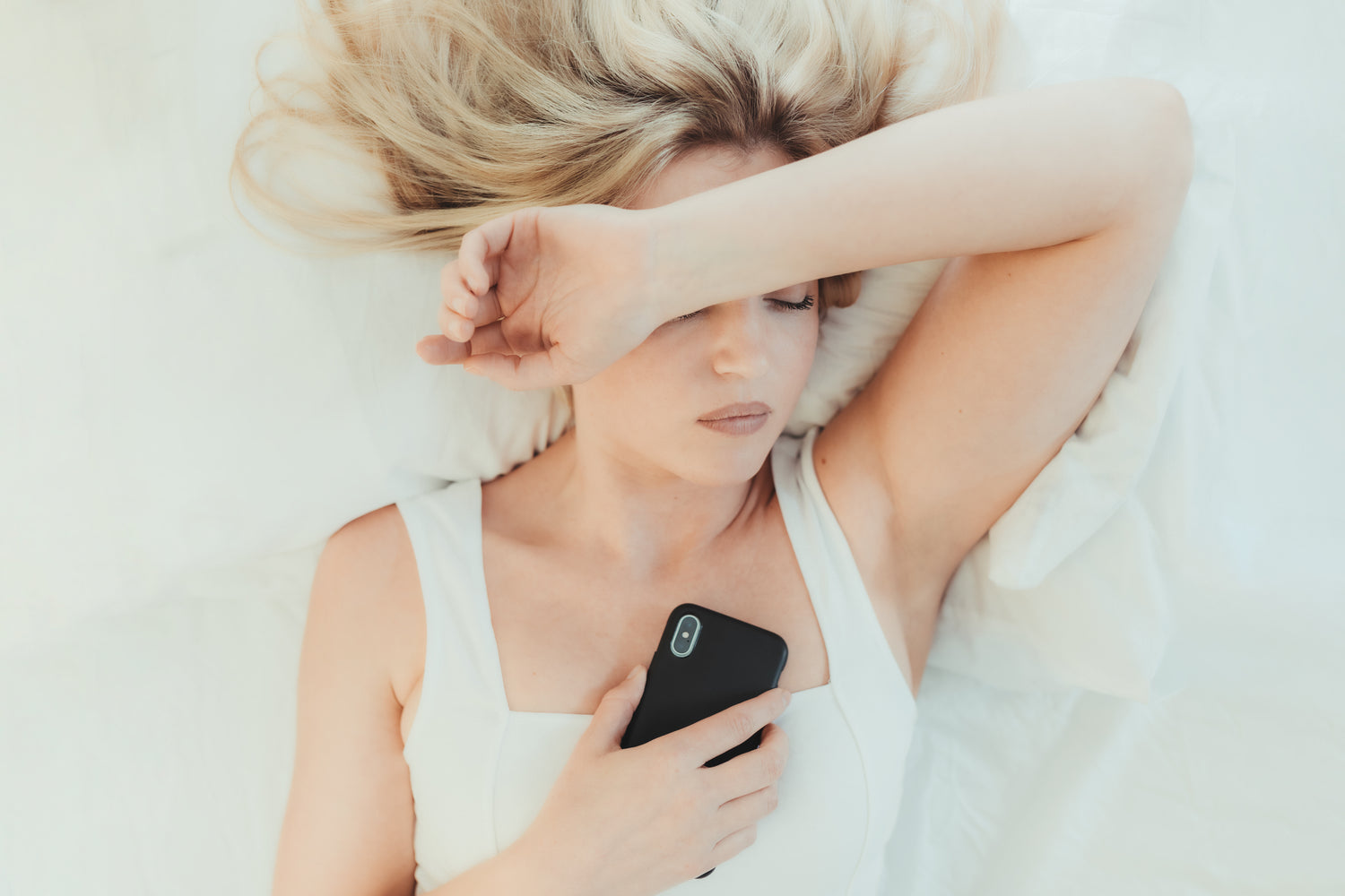 WOMAN-IN-BED-ON-HER-CELLPHONE